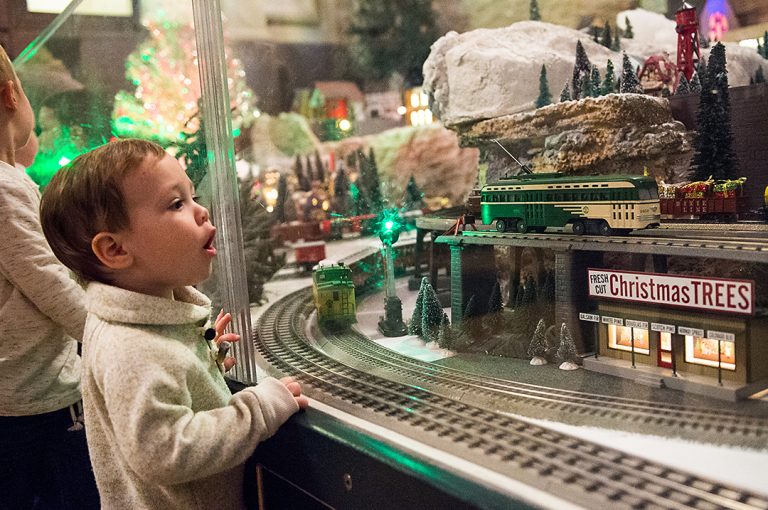 Photo of boy in front of model train display