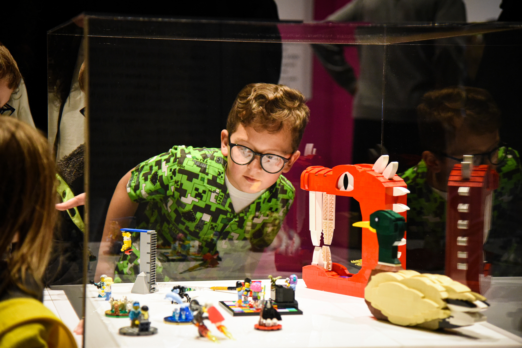 Photo from Bricktionary of kid looking at LEGO® Brick models